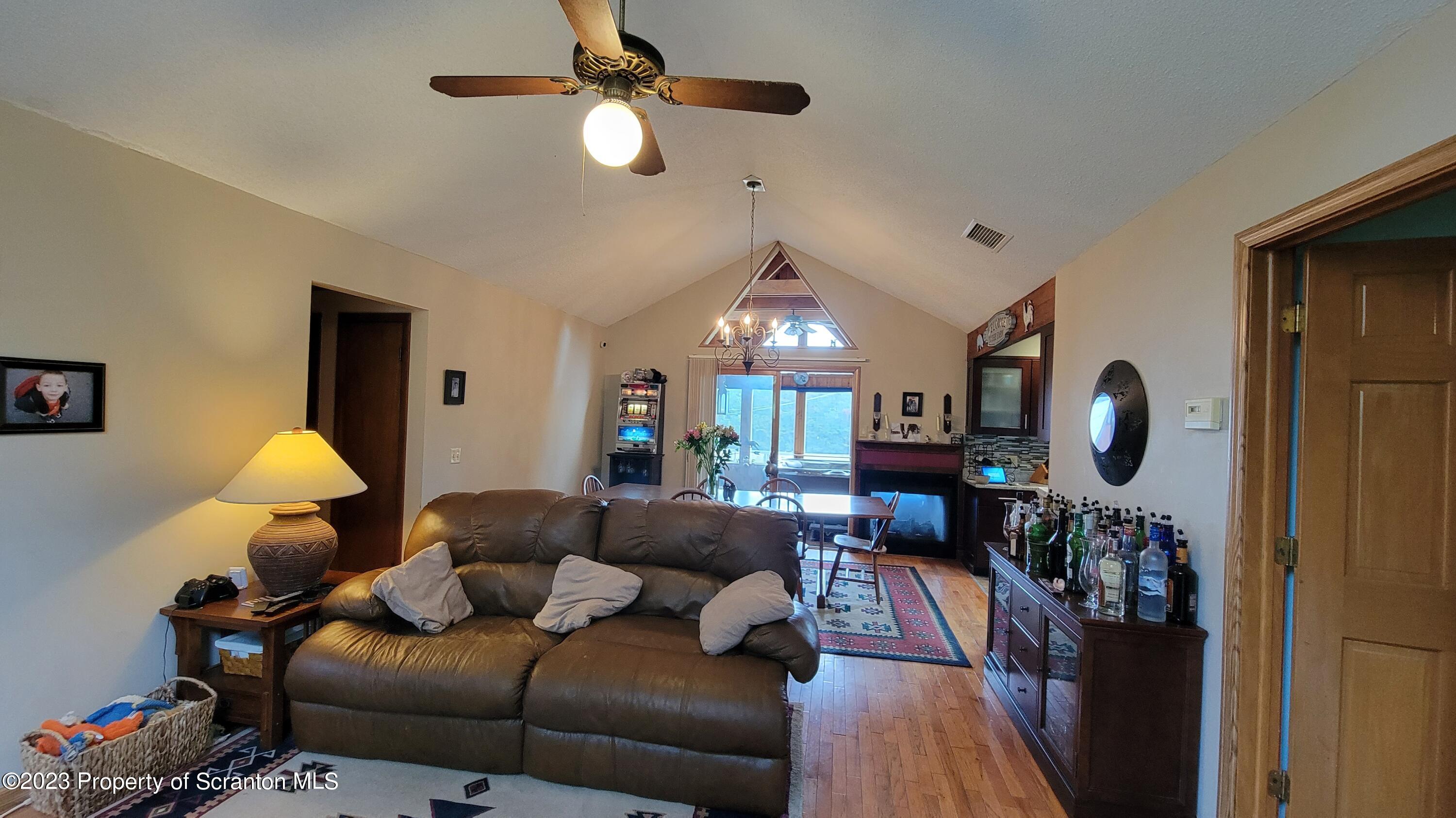 618 Kennedy Road Brackney, PA 18812 - Photo 16 of 35 a living room with furniture a fireplace and a chandelier