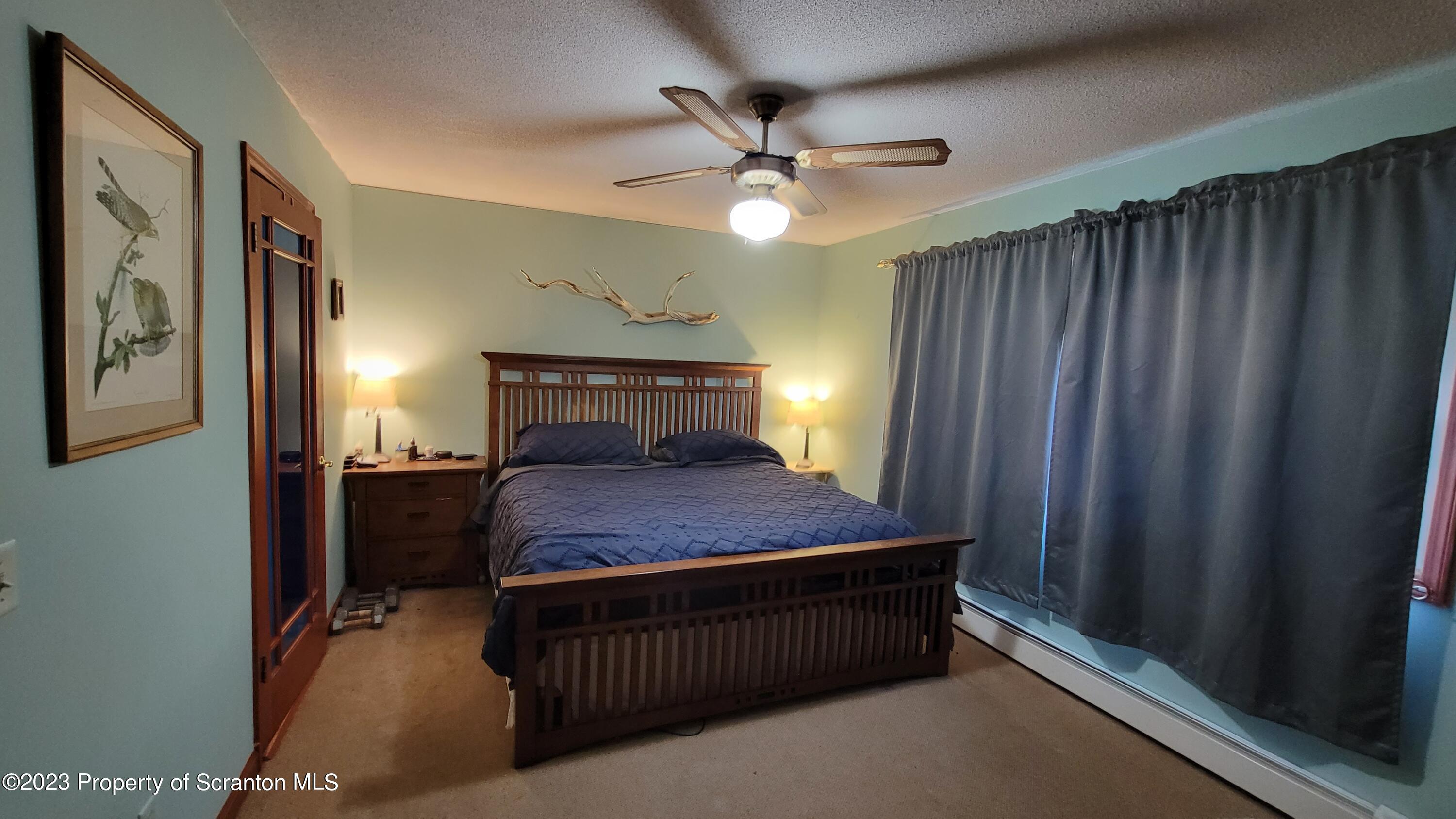 618 Kennedy Road Brackney, PA 18812 - Photo 22 of 35 a bedroom with a bed and a chandelier