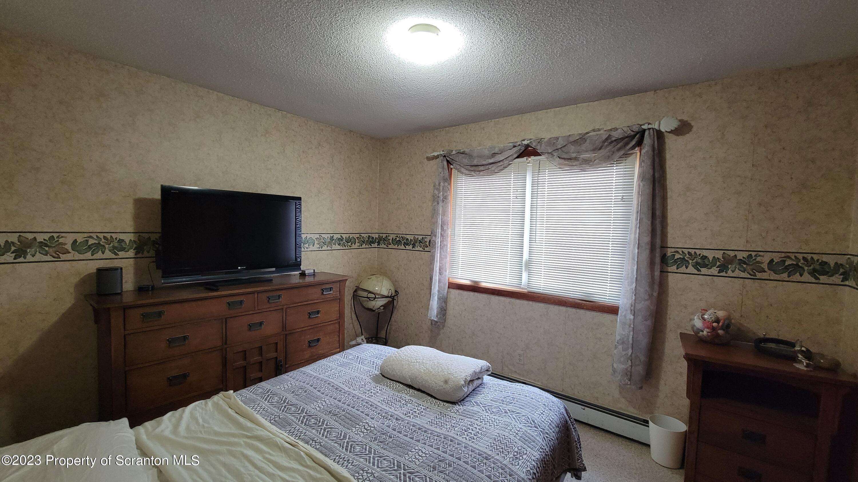 618 Kennedy Road Brackney, PA 18812 - Photo 24 of 35 a bedroom with a bed and a flat screen tv