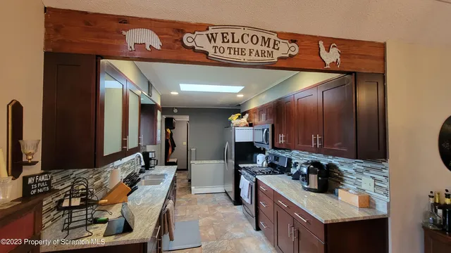 a kitchen with stainless steel appliances granite countertop a sink stove and cabinets