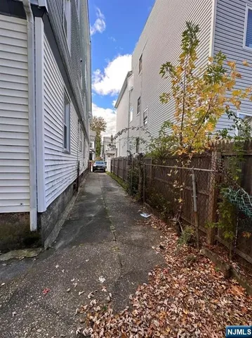 a view of a backyard with plants and brick wall