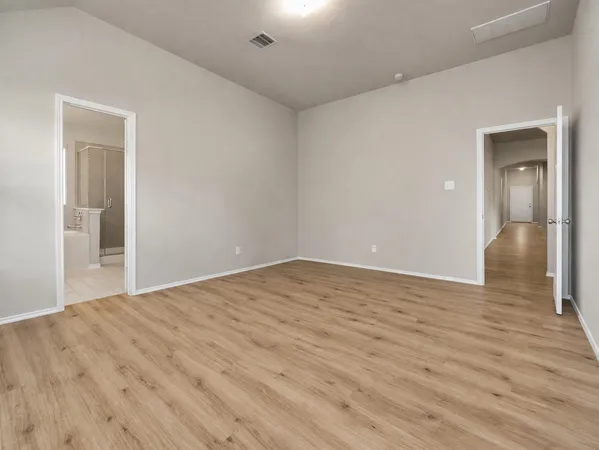 a view of empty room with wooden floor