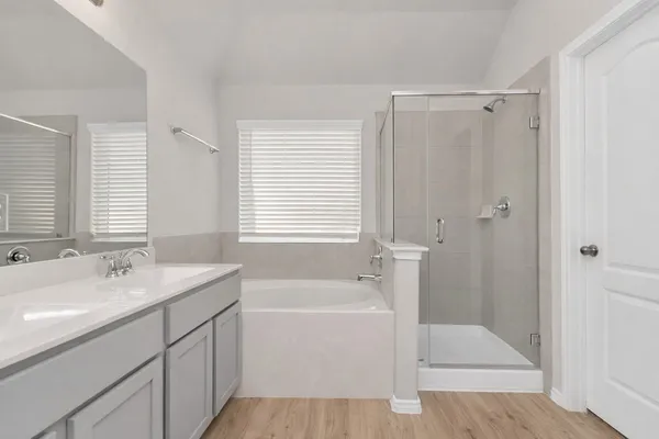 a bathroom with a tub sink shower and two mirror