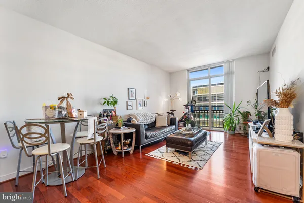 a living room with furniture dining table and wooden floor