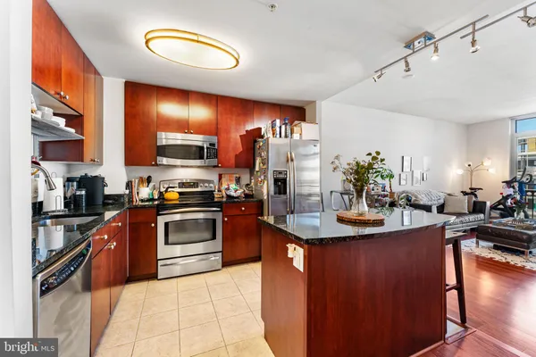 a kitchen with stainless steel appliances granite countertop a sink dishwasher stove and refrigerator
