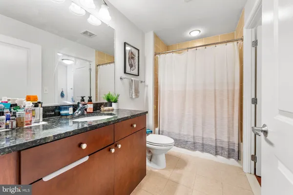 a spacious bathroom with a granite countertop sink toilet and shower