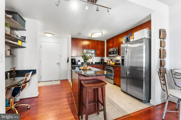 a kitchen with stainless steel appliances granite countertop a refrigerator a stove and a sink