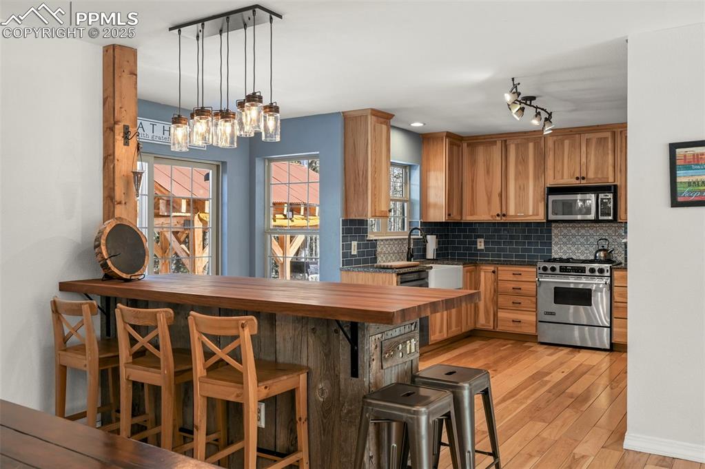 284 County Road 511 Divide, CO 80814 - Photo 11 of 49 a kitchen with stainless steel appliances a table chairs in it and wooden floors