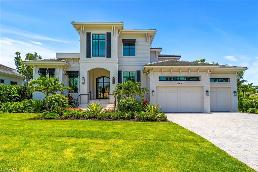 448 Devils Lane Naples, FL 34103 - Photo 1 of 15 a front view of a house with a garden