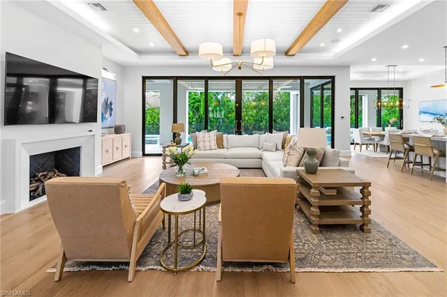 a living room with furniture fireplace and large windows