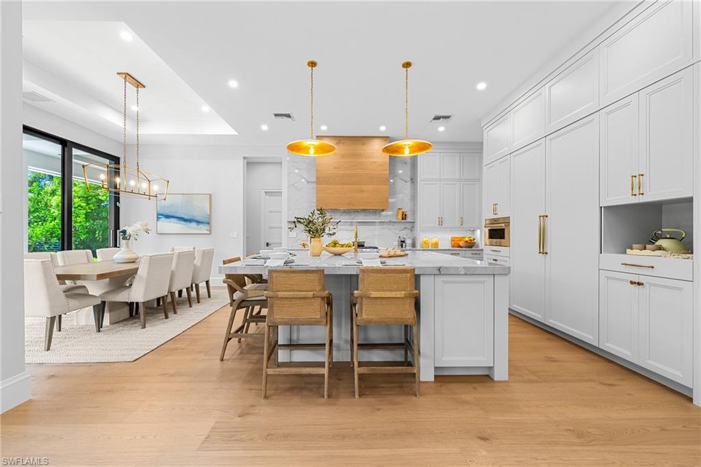 448 Devils Lane Naples, FL 34103 - Photo 4 of 15 a kitchen with a dining table chairs and white cabinets