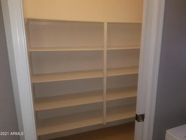 a view of walk in closet with empty racks
