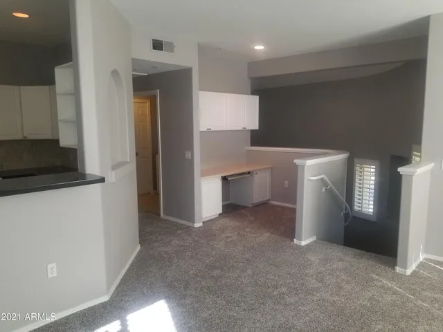 a view of a hallway to rooms and kitchen