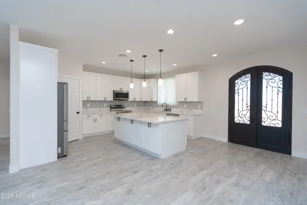 a kitchen with a refrigerator and white cabinets