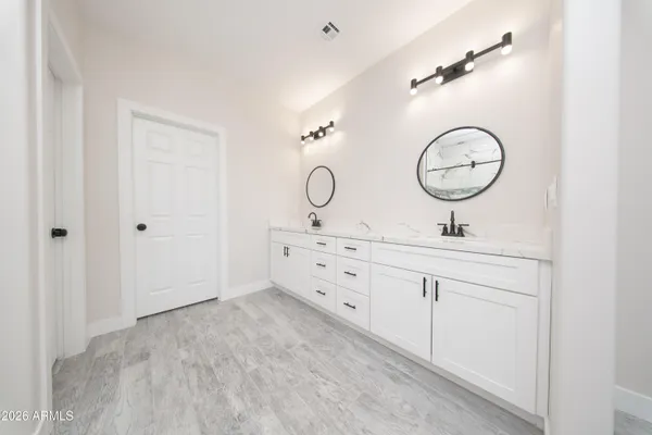 a bathroom with a double vanity sink and a mirror