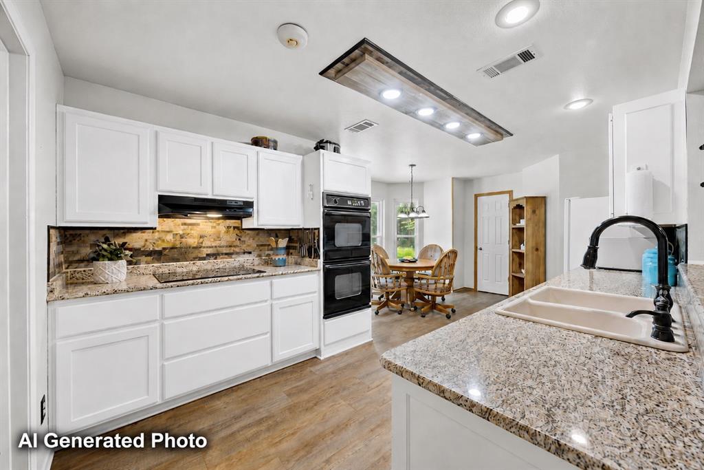 881 Wild Road Van Alstyne, TX 75495 - Photo 12 of 40 a kitchen with stainless steel appliances granite countertop a sink dishwasher a stove and white cabinets with wooden floor
