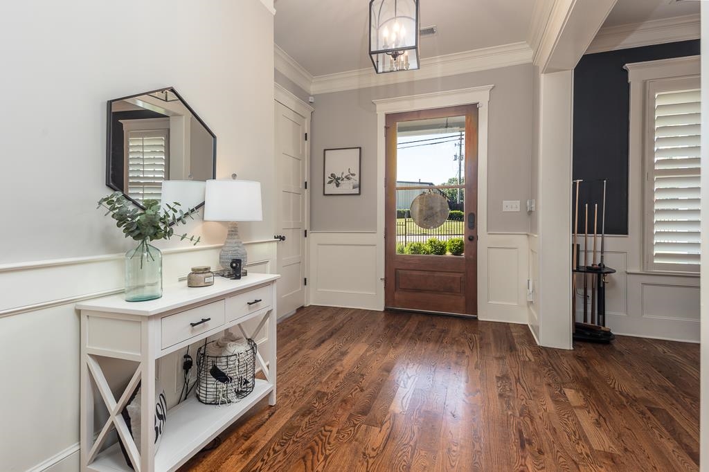 328 Washington Street Collierville, TN 38017 - Photo 7 of 33 Warm wood-finish flooring complements the detailed wainscoting and crown molding