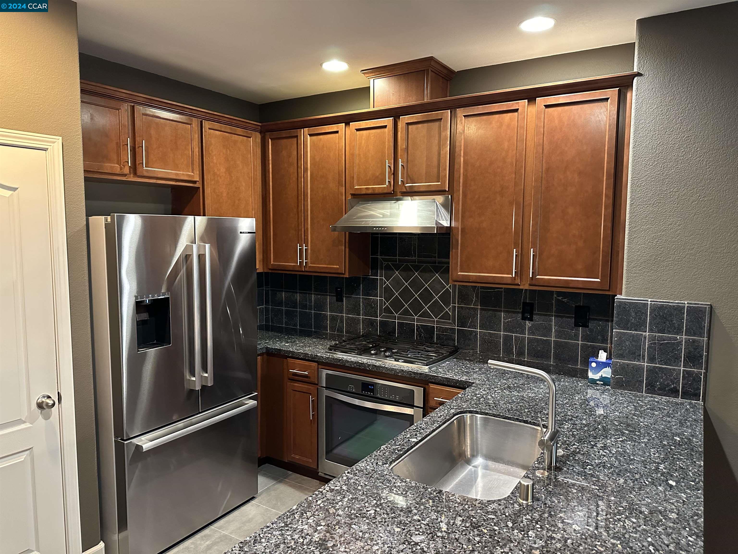 830 El Paseo Circle Walnut Creek, CA 94597 - Photo 4 of 16 a kitchen with stainless steel appliances granite countertop a refrigerator a sink a stove and blue cabinets