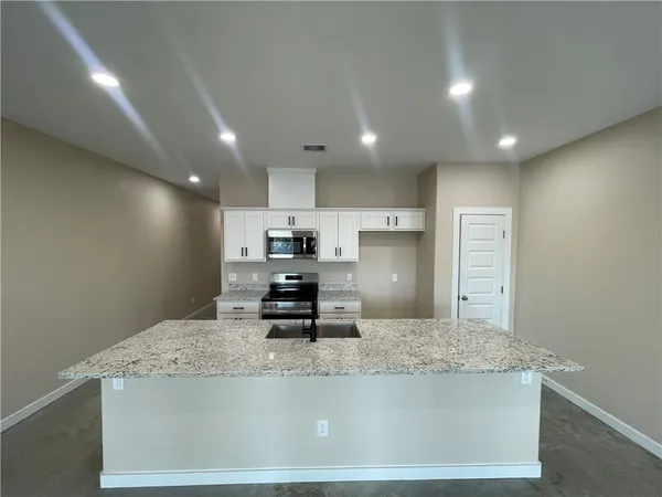 a view of kitchen with kitchen island a sink stainless steel appliances and cabinets