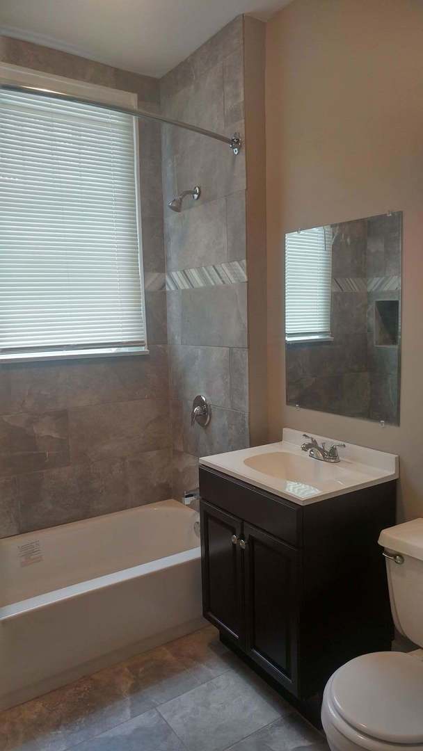 7412 South Prairie Avenue, Unit 1F Chicago, IL 60619 - Photo 4 of 6 a bathroom with a sink toilet and shower