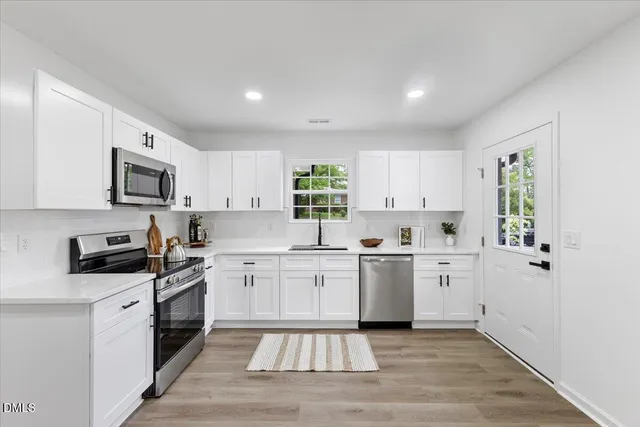 a kitchen with granite countertop white cabinets and white appliances