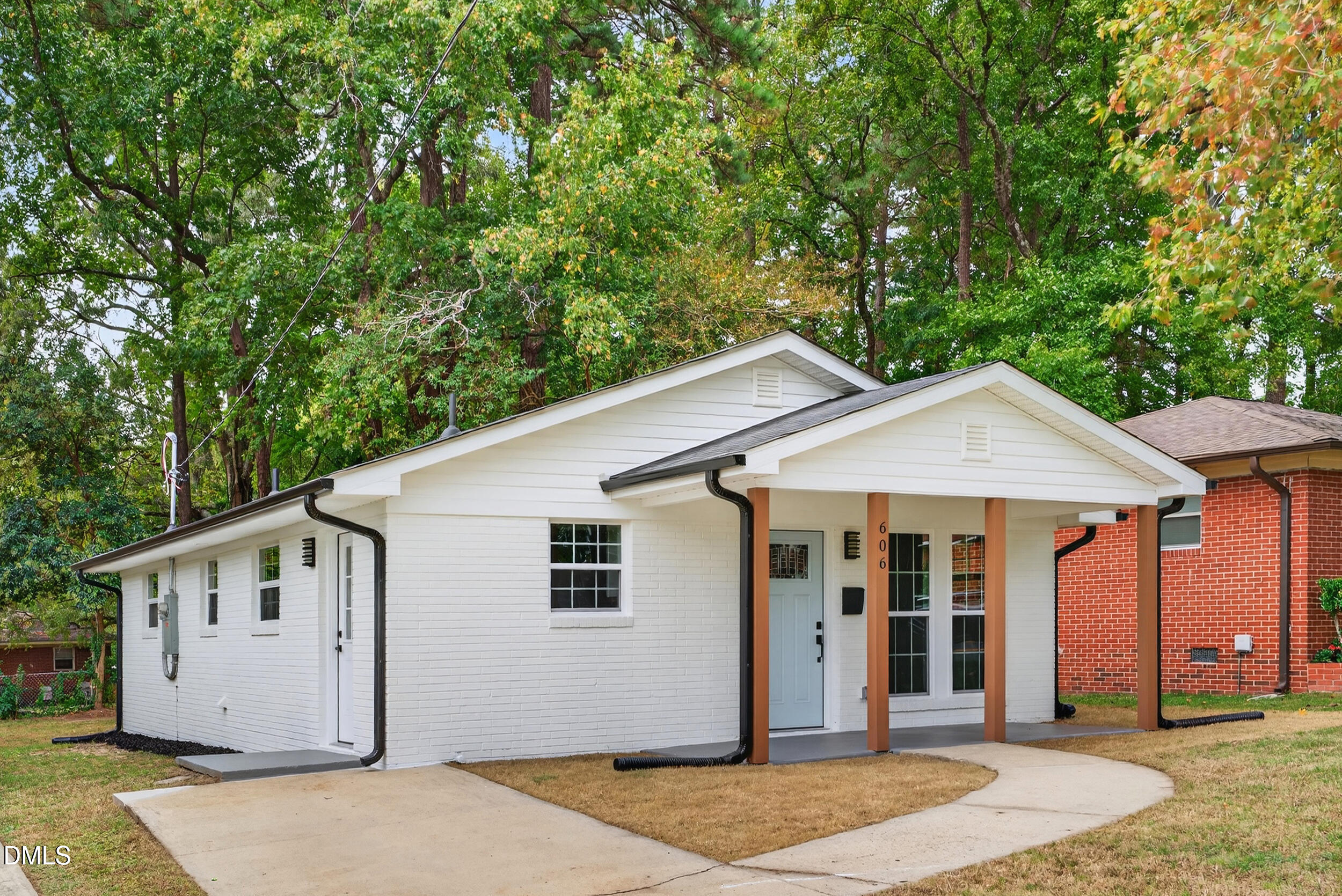 606 Cecil Street Durham, NC 27707 - Photo 3 of 25 a view of a white house with a big yard and large tree