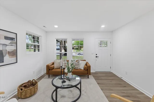a living room with furniture and wooden floor