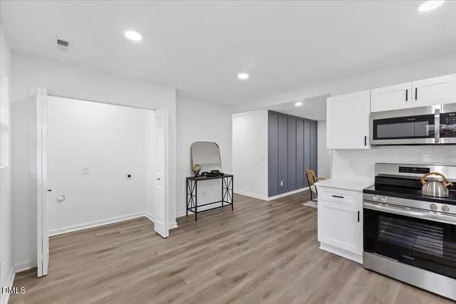 a kitchen with granite countertop a stove a sink and a refrigerator