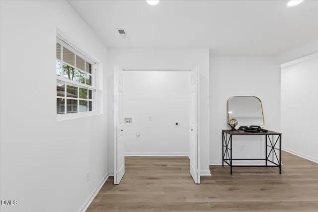 a view of a livingroom with wooden floor and a window
