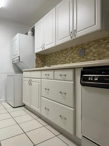 a kitchen with white cabinets and white appliances