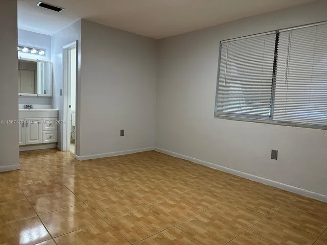 a view of an empty room with closet and a window