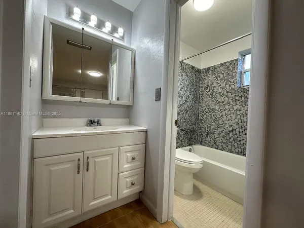 a bathroom with a sink a toilet a shower and a mirror