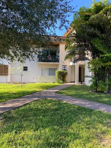 a view of a house with a yard and tree s