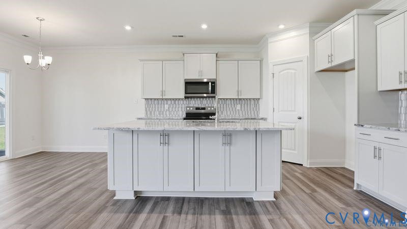 1792 Outrigger Drive Chester, VA 23836 - Photo 6 of 45 a kitchen with stainless steel appliances granite countertop a stove a sink and a refrigerator