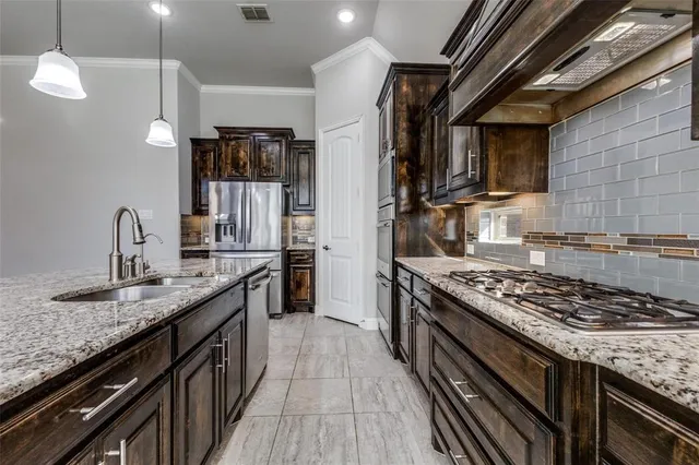 a kitchen with stainless steel appliances granite countertop a sink stove and cabinets