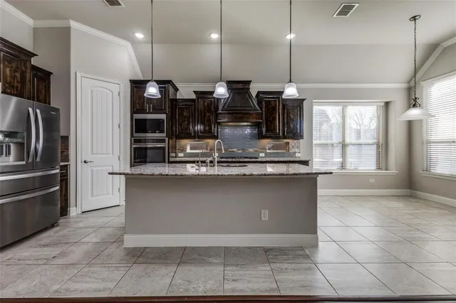 a kitchen with stainless steel appliances granite countertop a refrigerator a oven and a sink
