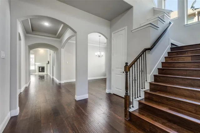 a view of a hallway with wooden floor and stairs