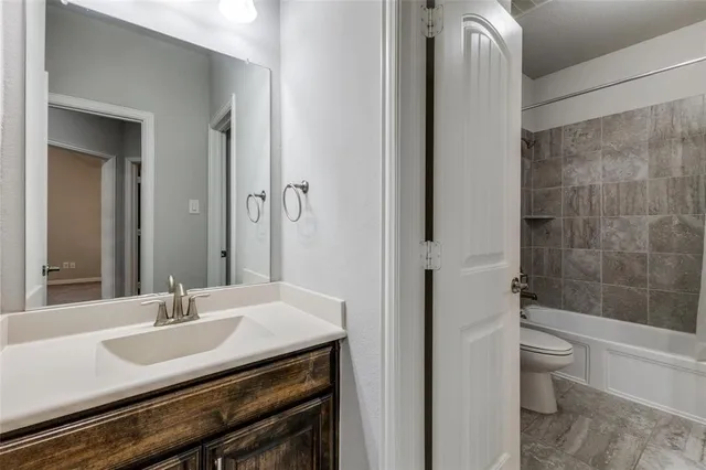 a bathroom with a granite countertop sink a toilet and shower