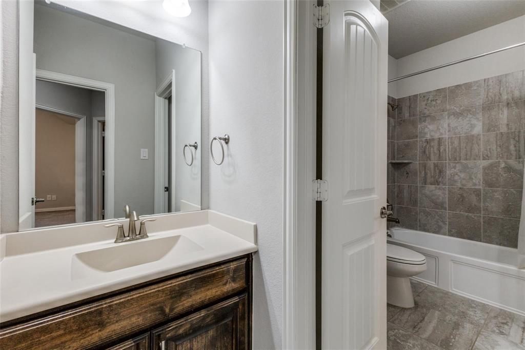 4412 Evenstar Way Plano, TX 75074 - Photo 7 of 30 a bathroom with a granite countertop sink a toilet and shower