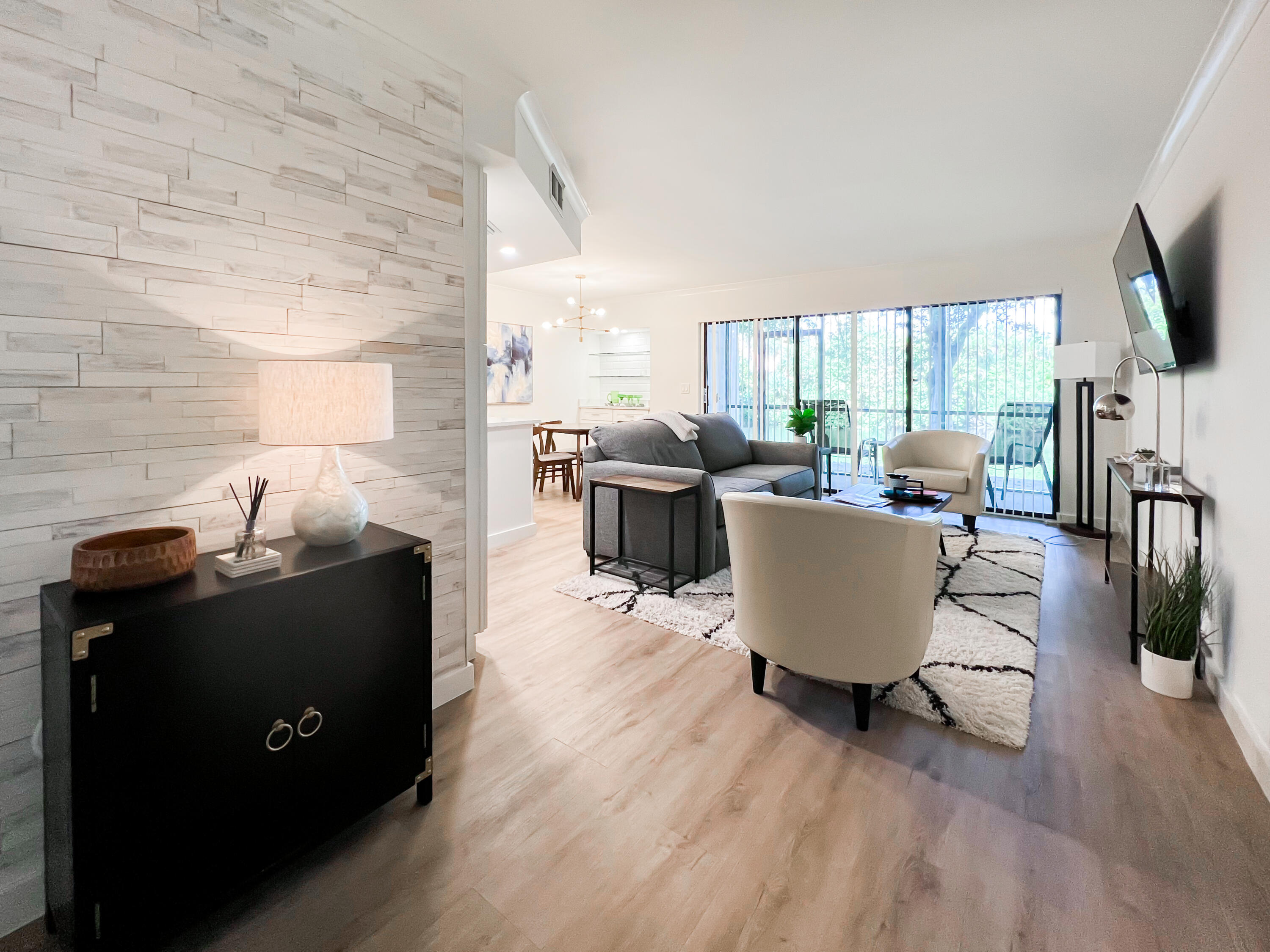 1605 Highway 1, Unit C103 Jupiter, FL 33477 - Photo 21 of 26 a living room with furniture a large window and a flat screen tv