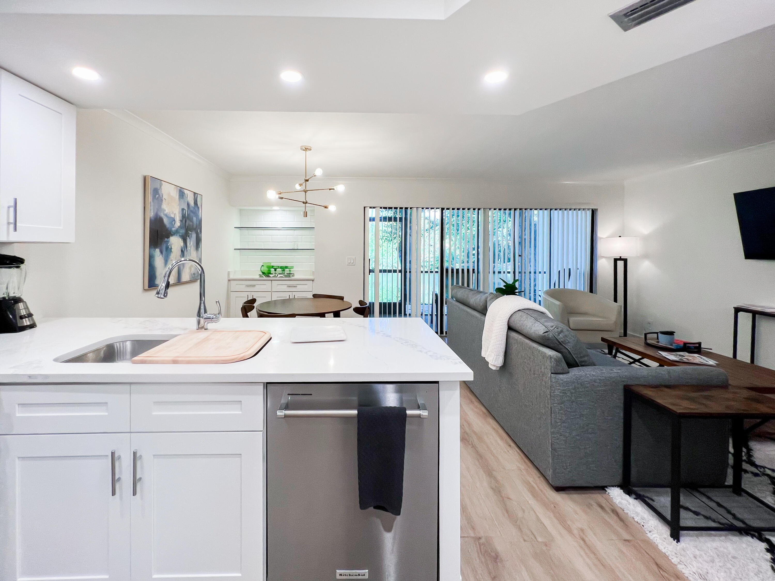1605 Highway 1, Unit C103 Jupiter, FL 33477 - Photo 5 of 26 a kitchen with a sink a counter top space and living room