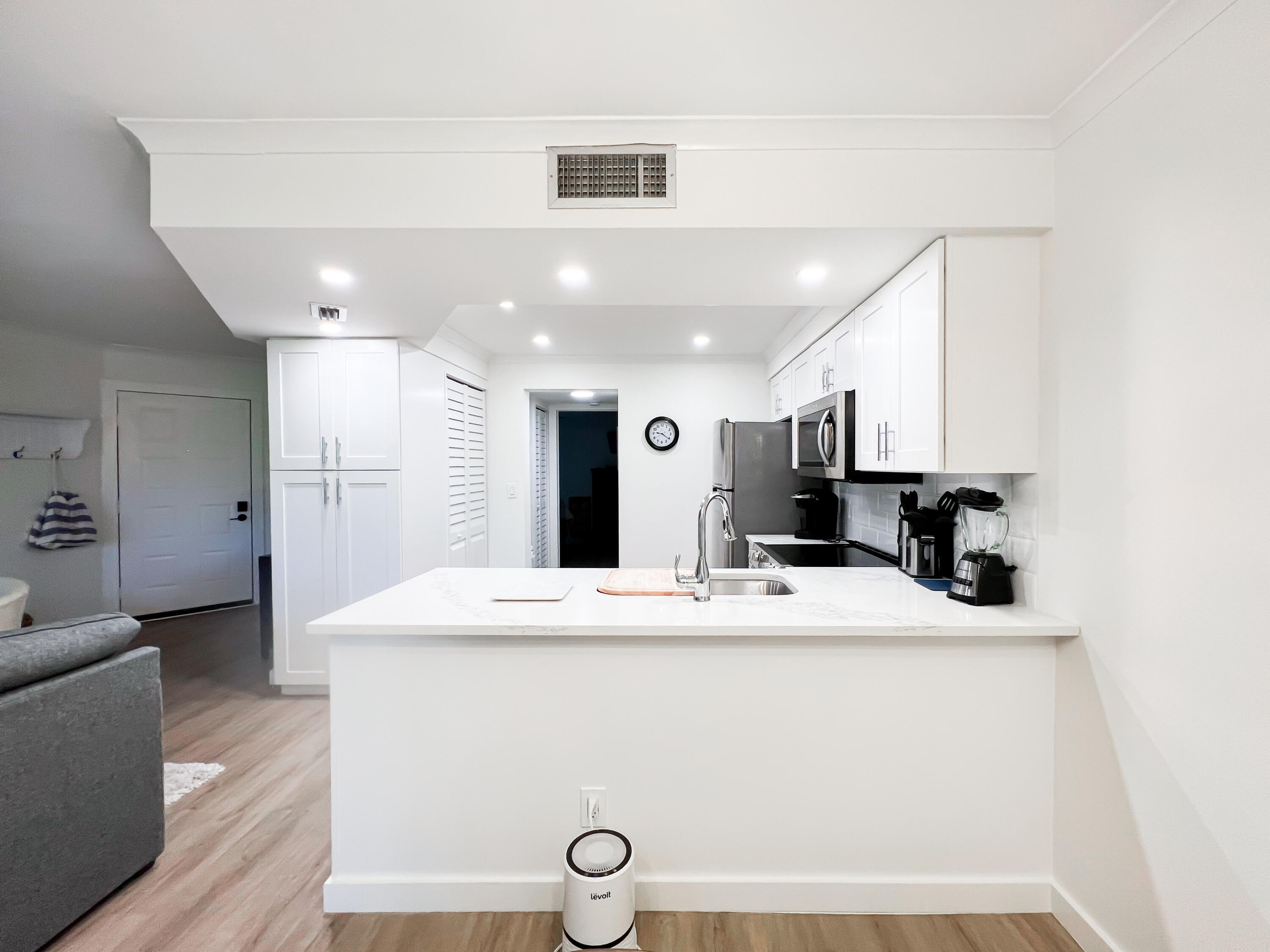 1605 Highway 1, Unit C103 Jupiter, FL 33477 - Photo 6 of 26 a large white kitchen with kitchen island a sink stainless steel appliances and cabinets