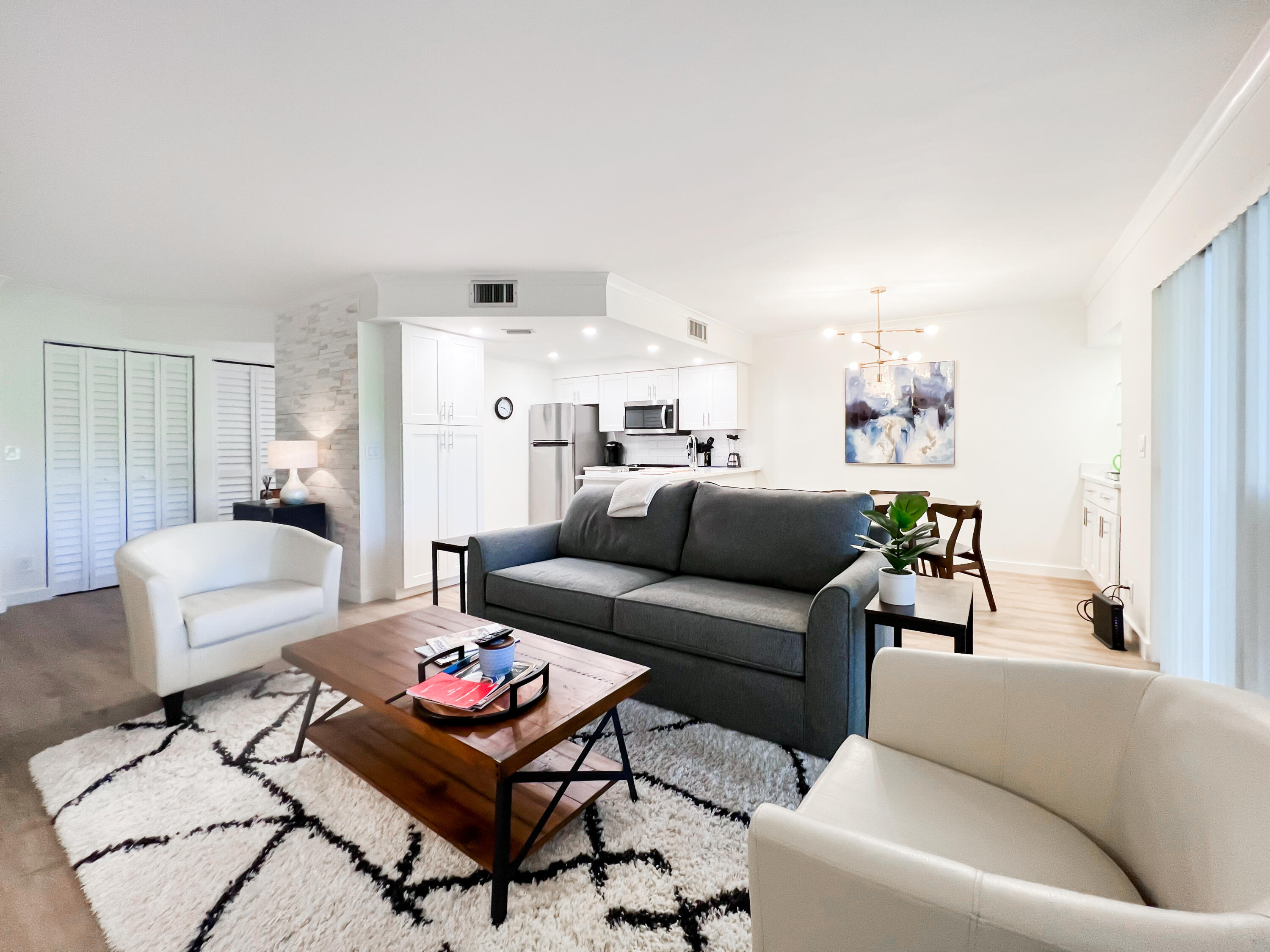 1605 Highway 1, Unit C103 Jupiter, FL 33477 - Photo 8 of 26 a living room with furniture and a rug
