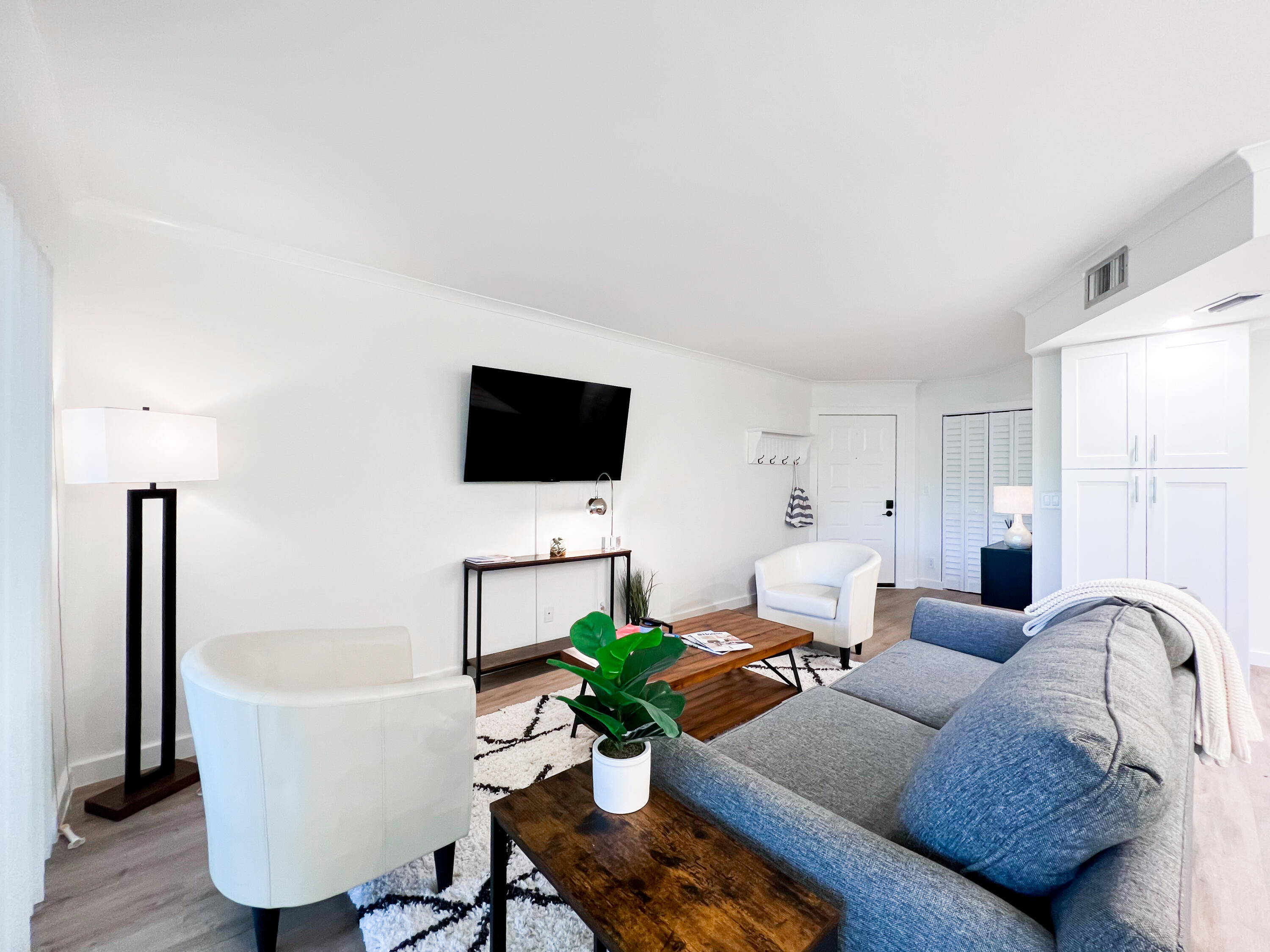 1605 Highway 1, Unit C103 Jupiter, FL 33477 - Photo 9 of 26 a living room with furniture a flat screen tv and a lamp