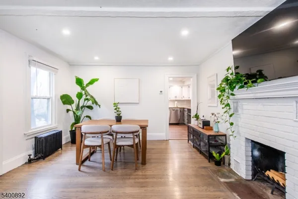 a dining room with furniture potted plants and wooden floor