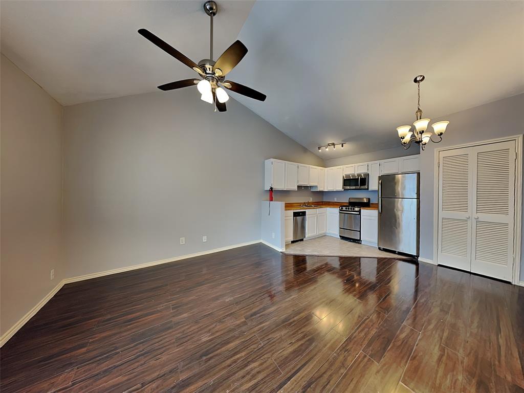 6108 Abrams Road, Unit 323 Dallas, TX 75231 - Photo 2 of 7 a view of a room with wooden floor a ceiling fan a ceiling fan and staircase