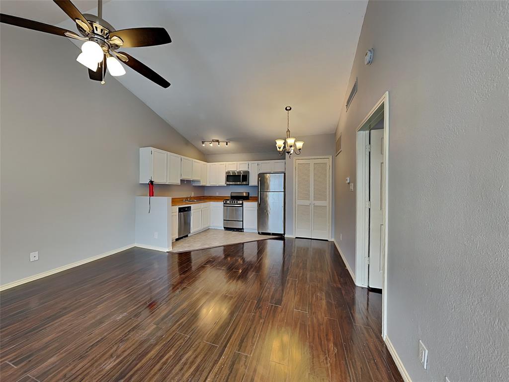 6108 Abrams Road, Unit 323 Dallas, TX 75231 - Photo 3 of 7 a view of a kitchen with a fridge wooden floor and a ceiling fan