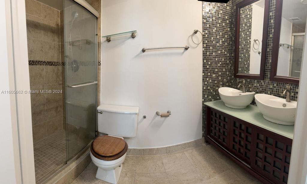 919 Hillcrest Drive, Unit 201 Hollywood, FL 33021 - Photo 13 of 14 a bathroom with a granite countertop toilet sink and shower