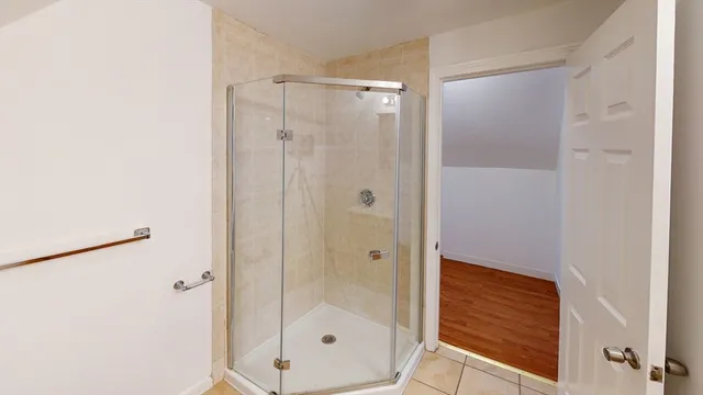 a bathroom with a shower and a glass door