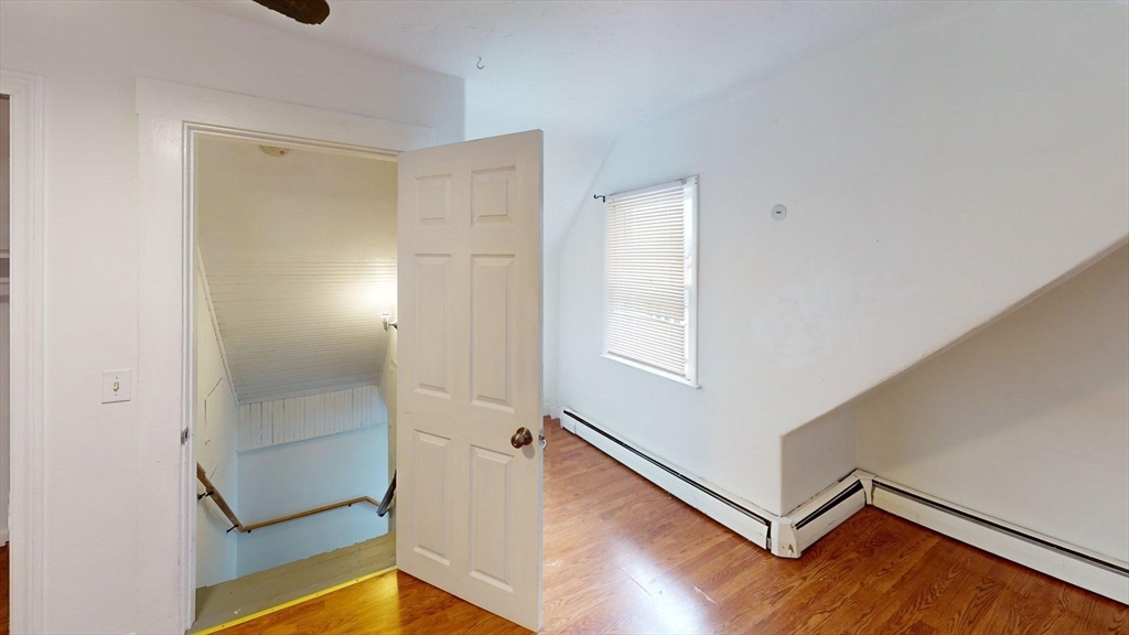 78 Fremont Street, Unit 78 Somerville, MA 02145 - Photo 19 of 30 an empty room with wooden floor and windows